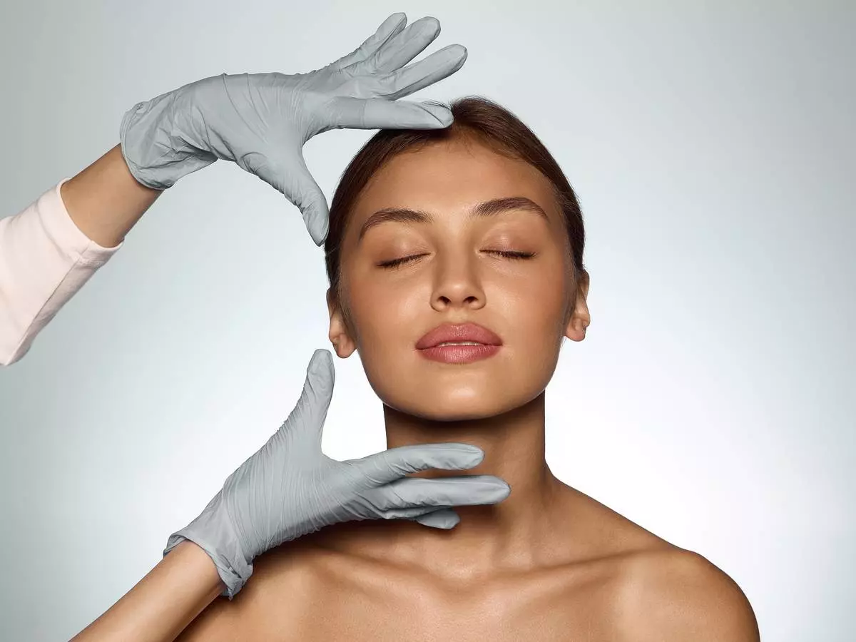 Dermatologue réalisant un traitement au laser dermatologique du visage en cabinet médical