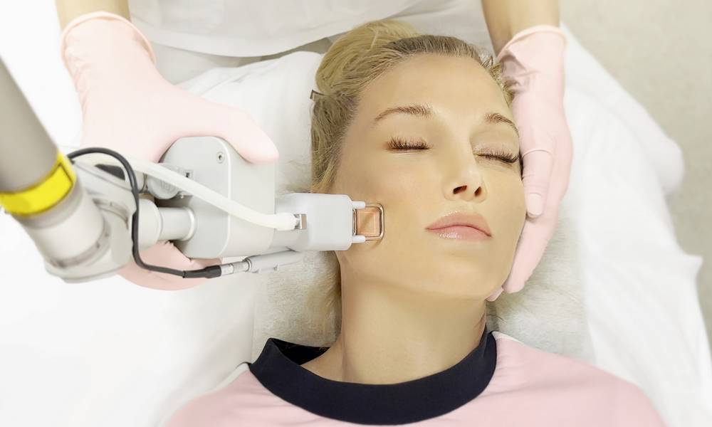 Dermatologue esthétique réalisant un traitement de laser dermatologique du visage à Paris