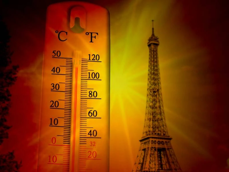 Thermomètre indiquant une forte chaleur devant la Tour Eiffel à Paris pendant une période de canicule, illustrant les risques d'hyponatrémie liés aux températures élevées.